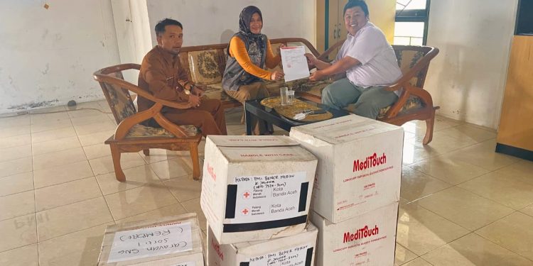 Ketua PMI Bener Meriah dr. Jawahir Syahputra.M.K.M saat meyerahkan bantuan Handscoon (sarung tangan) kepada Rumah Sakit Muyang Kute yang diwakili Ns. Raihana Kasi Pelayanan Medik. Selasa (30/12/2025). Foto : Doc PMI BM