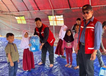 Ketua PMI Bener Meriah dr, Jawahir Syahputra,M.K.M bersama pegurus saat menyerahkan bantuan tas sekolah kepada anak-anak di Wih Tenang Uken, Senin (19/1/2025). Foto: Doc PMI BM
