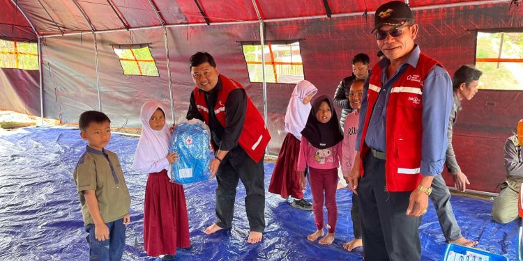 Ketua PMI Bener Meriah dr, Jawahir Syahputra,M.K.M bersama pegurus saat menyerahkan bantuan tas sekolah kepada anak-anak di Wih Tenang Uken, Senin (19/1/2025). Foto: Doc PMI BM