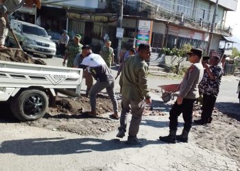 Forkopimcam Kecamatan Bandar saat menambal jalang berlubang di simpang bahgie Pondok Baru. Senin (9/3/2026). Foto: Hermansyah