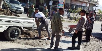 Forkopimcam Kecamatan Bandar saat menambal jalang berlubang di simpang bahgie Pondok Baru. Senin (9/3/2026). Foto: Hermansyah