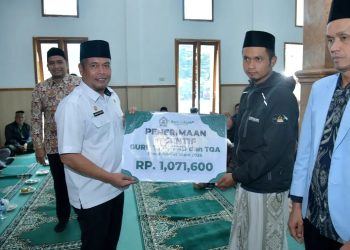 Sekda Kabupaten Bener Meriah, Riswandika Putra, S.STP., M.AP., saat menyerahkan honorarium guru TPA, di mesjid Nur Nabawi. Foto : Prokopim BM