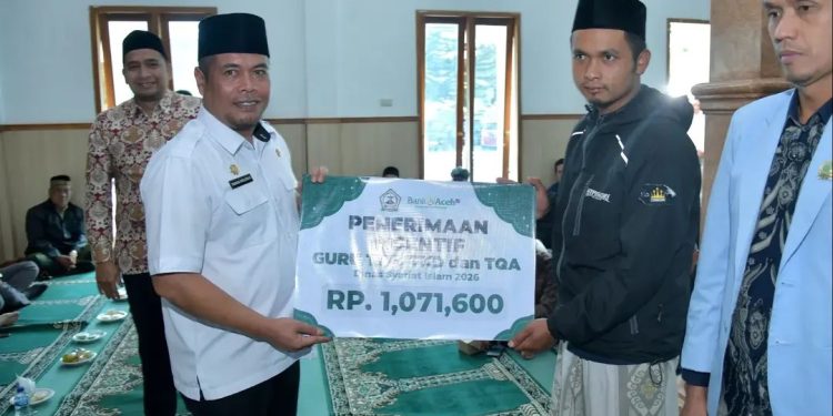 Sekda Kabupaten Bener Meriah, Riswandika Putra, S.STP., M.AP., saat menyerahkan honorarium guru TPA, di mesjid Nur Nabawi. Foto : Prokopim BM