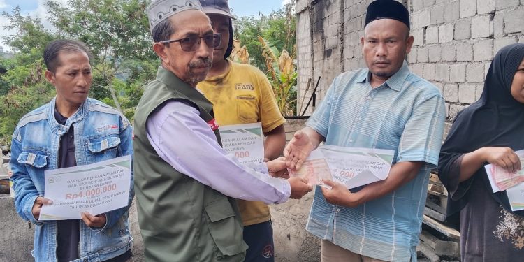 Ketua Baitul Mal Bener Meriah, Drs. Nawawi saat memberikan bantuan kepada masyarakat korban kebakaran di Seni Antara, Kec. Permata. Foto: Humas Baitul Mal BM